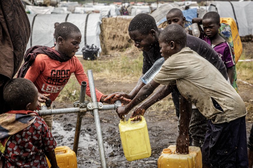 Les enfants réfugiées puisant de l'eau au robinet