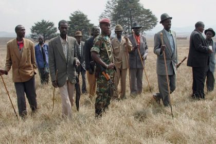 Un soldat rwandais et des villageois congolais portant des cannes traditionnelles marchent dans un champ à Minembwe, RDC 17 juillet 2002 (image d'illustration)