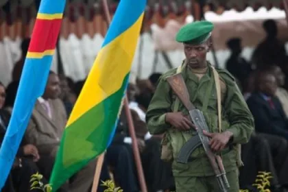 Photo d'illustration : Un militaire rwandais devant les drapeaux Congolais et Rwandais