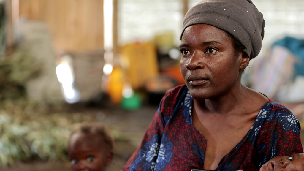 Photo d'une femme avec un enfant à l'arrière-plan. Crédit photo : Oxfam.